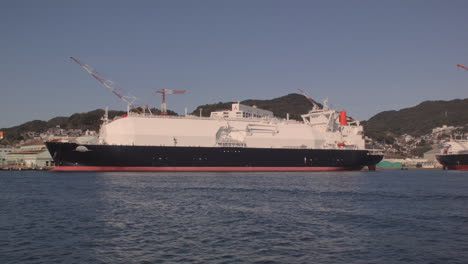 Segeln-Vorbei-An-Einem-Tanker,-Der-Im-Hafen-Von-Kobe,-Japan,-Angedockt-Ist