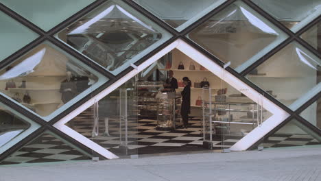 Static-shot-view-of-the-front-entrance-to-Prada-geometric-diamond-glass-architecture-store-in-downtown-Tokyo