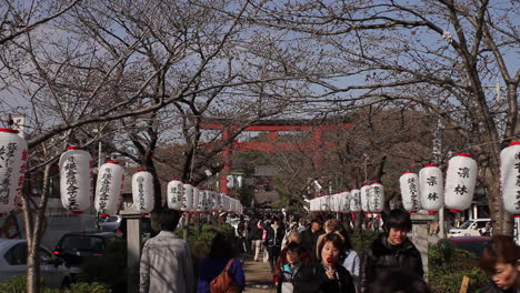 Crowds-walking-between-hanging-lanterns-in-Kamakura,-Japan