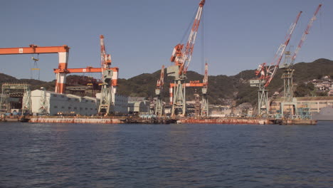 Segeln-Vorbei-An-Hafenportalkränen-Im-Hafen-Von-Kobe,-Japan