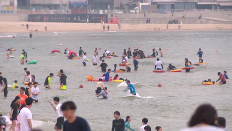 Gente-Nadando-Y-Disfrutando-Del-Agua-En-La-Playa-De-Haeundae,-Busan,-Corea-Del-Sur.