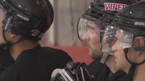 Close-up-of-hockey-players-sitting-on-bench-watching-their-team-play