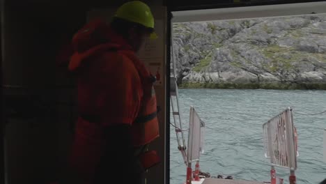 View-From-Inside-Boat-Of-Boat-Ramp-With-Railings-With-Boat-Crew-Wearing-Life-Jacket