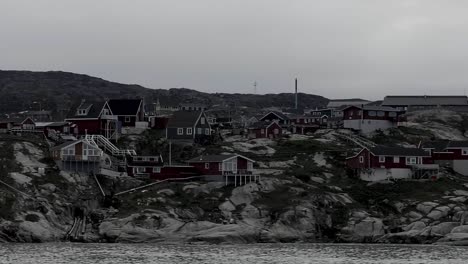Segeln-Sie-An-Häusern-Vorbei,-Die-An-Der-Felsigen-Küste-Grönlands-Liegen