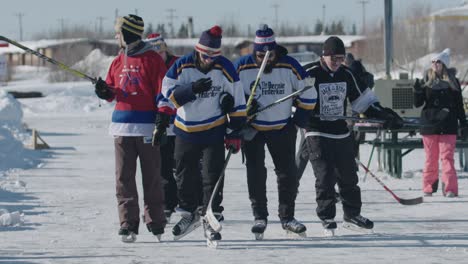 Group-of-pond-hockey-players-skating-toward-camera-in-slow-motion