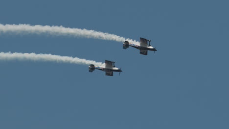 Primer-Plano-De-Un-Cohete-F1-Y-Aviones-Harmon-Rocket-Ii-Volando-Invertidos-Con-Estelas-De-Humo-En-Una-Exhibición-Aérea-En-Cámara-Lenta