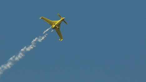Closeup-of-aerobatic-stunt-plane-climbing-and-rolling-with-smoke-trail