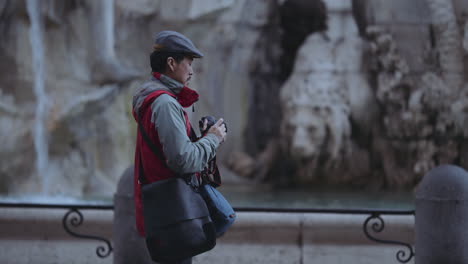 Clip-of-a-tourist-taking-photos-at-Fountain-of-the-Four-Rivers-in-Navona-Square-or-Piazza-Navona-in-Rome,-Italy