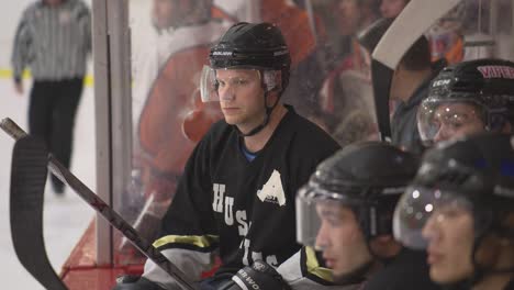 El-Capitán-Asistente-En-Uniforme-Se-Sienta-En-El-Banco-Viendo-Jugar-A-Otros-Jugadores-De-Hockey.