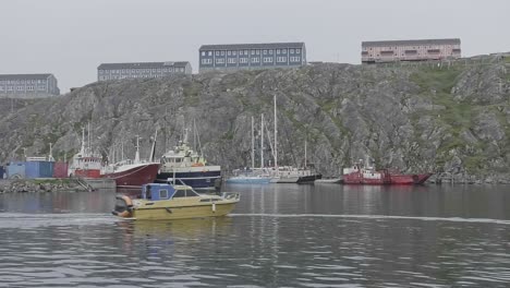 Barco-Pasando-Por-El-Puerto-Local-En-Nuuk-Con-Edificios-De-Apartamentos-En-El-Fondo-En-La-Cima-Del-Acantilado