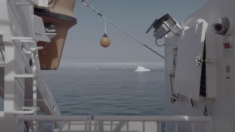 Blick-Von-Der-Decksreling-Auf-Ein-Schiff,-Das-An-Schwimmenden-Eisbergen-Im-Grönlandmeer-Vorbeisegelt
