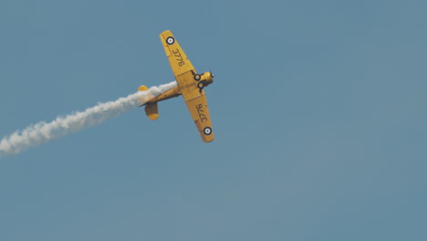 Close-up-of-North-American-Harvard-Mark-IV-airplane-performing-aileron-roll-with-undercarriage-visible-at-airshow-in-slow-motion