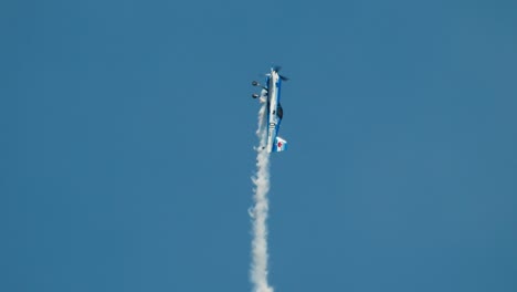 Closeup-aerobatic-stunt-plane-in-steep-climb-with-aileron-rolls