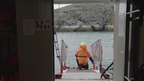 Bootsbesatzungsmitglied-Wartet-Auf-Der-Rampe-Darauf,-Dass-Das-Rettungsboot-Kommt-Und-Damit-In-Grönland-Festmacht
