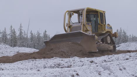 Plano-Amplio-De-Una-Topadora-Empujando-Tierra-Cubierta-De-Nieve-En-El-Lugar-De-Trabajo