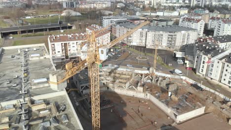 Aerial-shot-of-a-contruction-site-with-big-high-crane-escavator-working-for-build-up-a-residential-quarter-urban-area