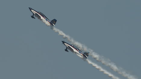 Close-up-of-a-F1-Rocket-and-Harmon-Rocket-II-airplanes-climbing-together-with-smoke-trails-at-an-airshow-in-slow-motion