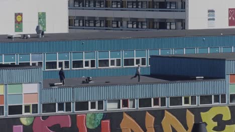 Abgesperrte-Sicht-Auf-Zwei-Jugendliche,-Die-Auf-Dem-Dach-Laufen-Und-Fangen-Auf-Einem-Gebäude-In-Nuuk,-Grönland,-Spielen