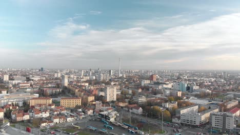 Drone-fly-over-Zagreb,-with-a-big-shopping-mall-and-a-bus-parking-stand,-traffic-around-the-busy-capital-of-Croatia