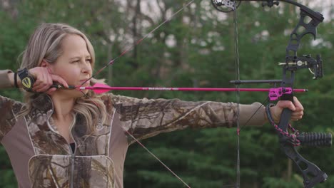 Medium-shot-of-female-archer-aiming-and-releasing-arrow-from-compound-bow