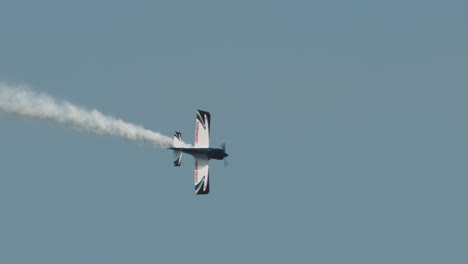 Close-up-of-F1-Rocket-or-Harmon-Rocket-II-airplane-performing-aileron-roll-with-smoke-trail-at-airshow-in-slow-motion