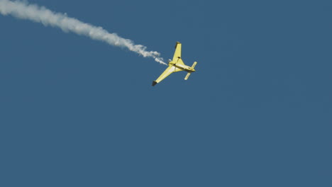 Closeup-aerobatic-stunt-plane-rolling-into-dive-with-smoke-trail