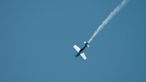 Close-up-aerobatic-stunt-plane-doing-aileron-rolls-while-diving-in-slow-motion