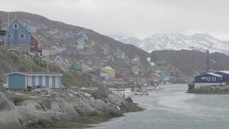 Segeln-Sie-Langsam-An-Einer-Bucht-Mit-Bunten-Häusern-An-Der-Felsigen-Küste-Grönlands-Vorbei
