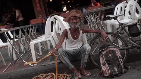 Un-Hombre-En-El-Mercado-Callejero-Saludando-Con-Su-Serpiente