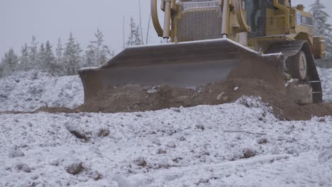 Bulldozer-Empuja-Tierra-Cubierta-De-Nieve-En-Un-Paisaje-árido