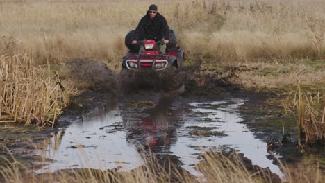 Jinete-De-ATV-Golpeando-Un-Pantano-De-Barro-A-Alta-Velocidad-Hacia-La-Cámara