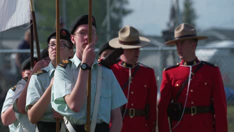 Kanadische-Armeekadetten-Halten-Fahnen-Mit-RCMP-Offizieren-Im-Hintergrund