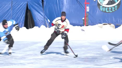 Fast-male-hockey-player-out-skates-his-opponents-at-pond-hockey