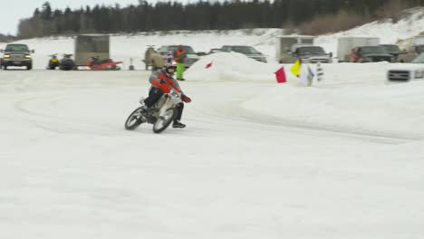 Snowcross-motocross-racer-going-around-corner-on-ice-track-at-high-speed