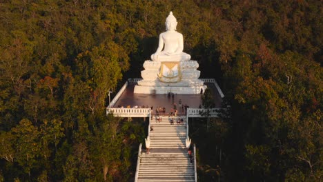 Big-Pai-Buddha-statue-and-forest-at-sunset-in-Thailand,-aerial-push-in