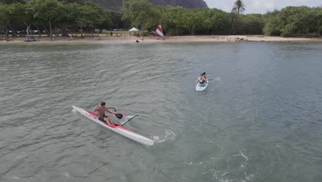 Caucasian-lady-paddle-surfboard-and-man-in-kayak-at-Kualoa-beach