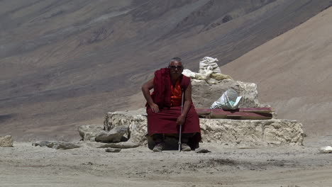 Monje-Nepalés-Solitario-Sentado-En-Las-Rocas-Del-Terreno-Del-Himalaya,-Plano-Amplio