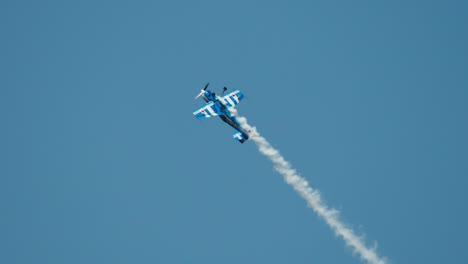 Close-up-aerobatic-stunt-plane-doing-slow-aileron-rolls-while-climbing