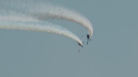 Un-Cohete-F1-Y-Un-Avión-Harmon-Rocket-II-Realizan-Un-Giro-Cerrado-Con-Estelas-De-Humo-En-Una-Exhibición-Aérea-En-Cámara-Lenta