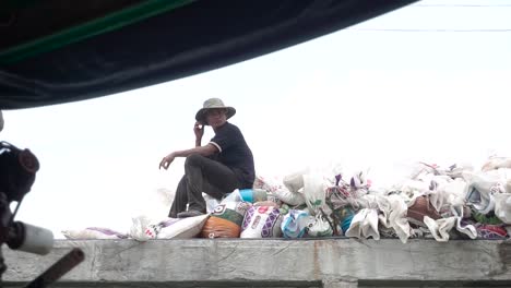 Fisherman-sitting-on-a-pier-sitting-on-a-pile-of-trash