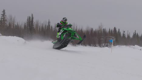 Schneemobil-Rennfahrer-Laufsteg-Arctic-Cat-über-Hügel-Im-Schneetreiben