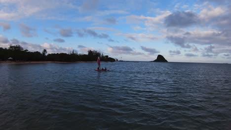 Aerial-FPV-follow-tracks-coastal-sailing-canoe-with-china-man's-hat-in-background