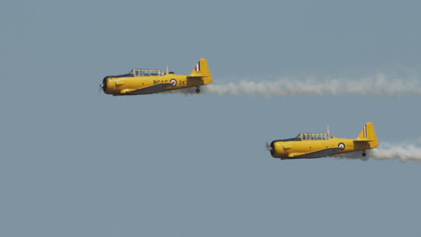 Close-up-of-two-North-American-Harvard-Mark-IV-airplanes-performing-flyby-at-airshow-in-slow-motion