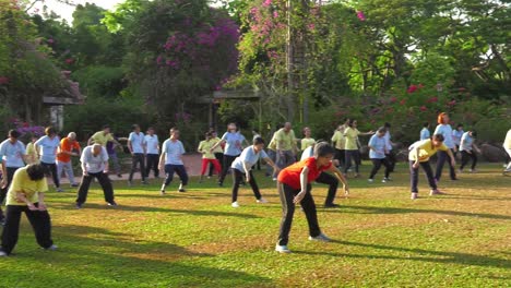 Große-Gruppe-Von-Menschen-Mittleren-Alters-Beim-Outdoor-Yoga-In-Singapur-–-Mittlere-Schwenkaufnahme