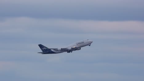 A-Lufthansa-747-airplane-takes-off-and-gracefully-ascends-into-the-sky-on-a-cloudy-day-from-Toronto,-Canada