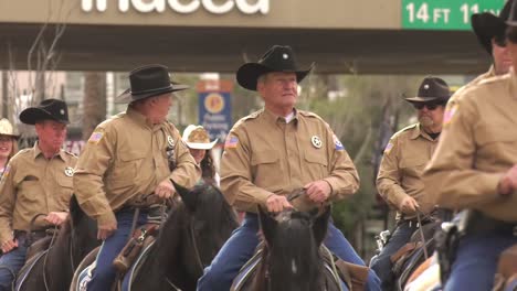 Veteran-Police-officers-commemorating-Memorial-Day-riding-horses-during-parade---Medium-long-Tracking-shot