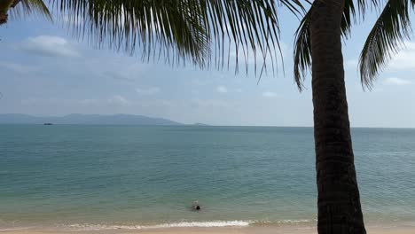Person-Swimming-in-Gulf-of-Thailand-on-Maenam-Beach-in-Koh-Samui,-Thailand
