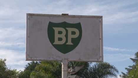 View-Of-Old-Retro-BP-Sign-Against-Trees-And-Rolling-Clouds