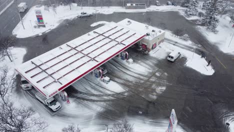 Aerial-view-flyover-and-flythrough-of-winter-gas-station,-Canada