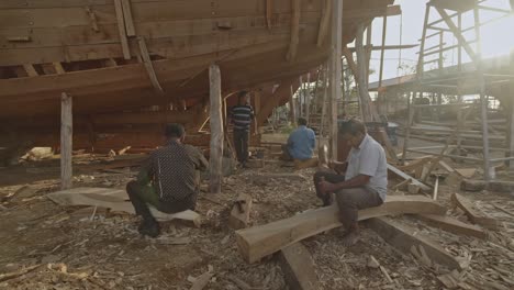 Group-Of-Artisans-Using-Chisel-And-Hammers-Crafting-Dhow-Boat-In-Sur,-Oman